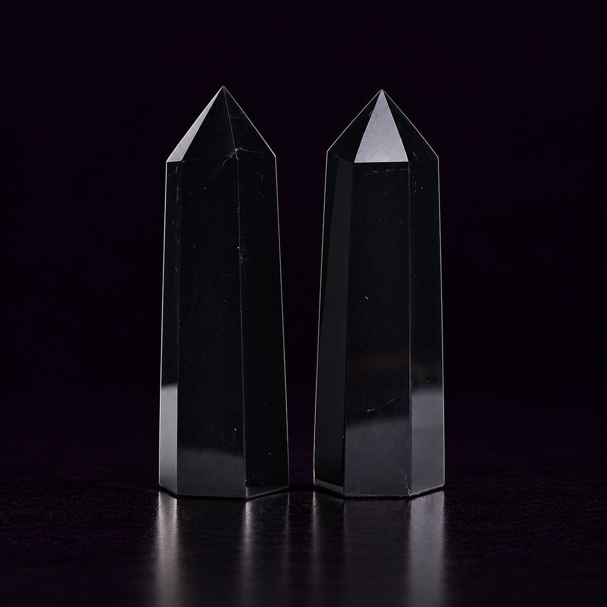 Black Obsidian crystal wand standing on a dark altar for shadow work and energy cleansing.
