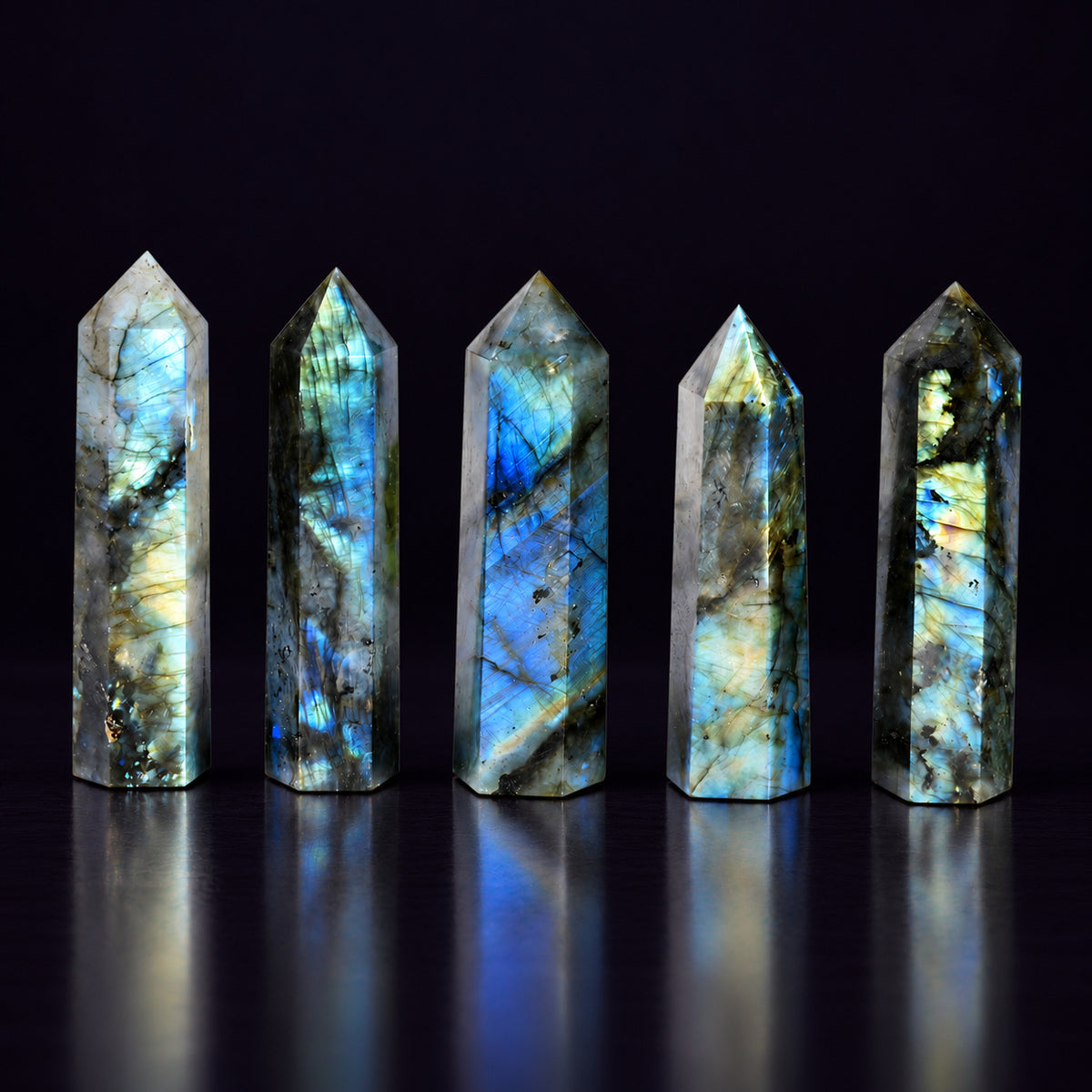 Natural Labradorite obelisk dimensions measuring approximately 7–9 cm (2.8–3.5 in) held in hand.